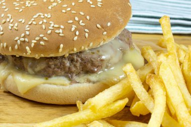 Tahta kesme tahtasına sığır burger ve patates kızartması..