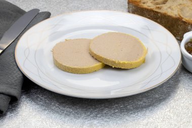 Beyaz tabakta kaz ciğeri dilimleri.