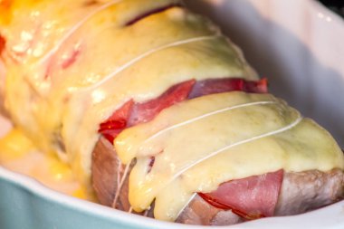 Çiğ domuz rostosu. Pişirmeye hazır. Et ve peynirli rulo. 