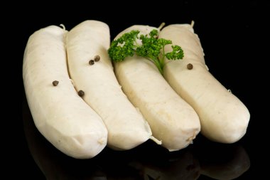 Beyaz kanlı sosisler, siyah arkaplanda beyaz puding. 