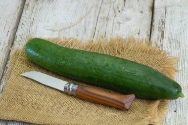 Tahta masada taze salatalık ve bıçak.