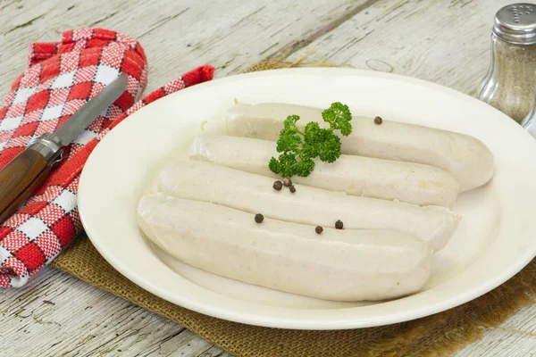 Beyaz kanlı sosisler, beyaz tabakta beyaz puding.