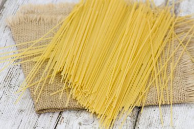 Ahşap masada çiğ spagetti.