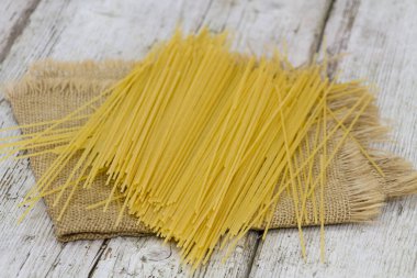 Ahşap masada çiğ spagetti.