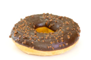 Çikolata kaplı çörek ve beyaz arka planda serpiştirilmiş çikolata.