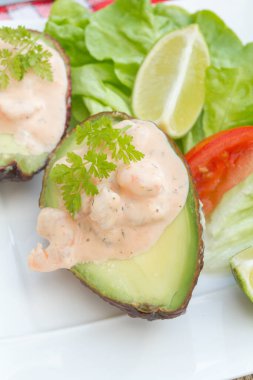 Karides avokado tabağı. Doldurulmuş avokado, marul ve limon tabakta. 