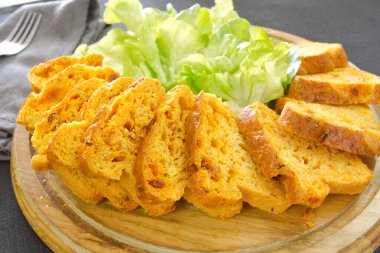 Tahtada yeşillikler olan tuzlu pasta.