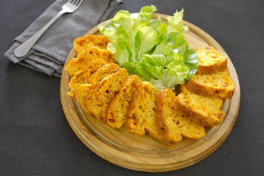 Tahtada yeşillikler olan tuzlu pasta.