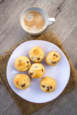 Çikolata parçacıklı ev yapımı kekler ve bir fincan kapuçino. 