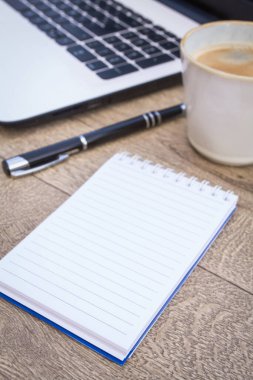 dizüstü bilgisayar, kalem ve kahve fincanı olan defter.