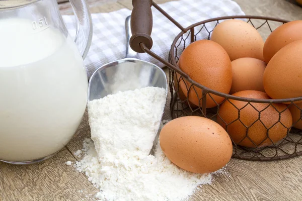 flour, milk, eggs on wooden table