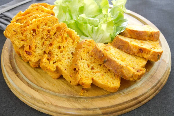 Tahtada yeşillikler olan tuzlu pasta.