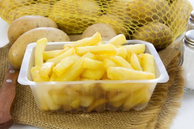 Kavanozda patates kızartması ve çiğ patates. 