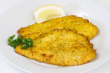 Tabağında limon olan balık filetosu. 
