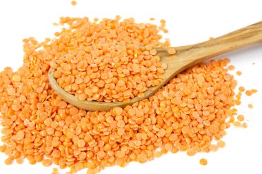 Beyaz arka planda izole edilmiş tahta kaşıkta kırmızı mercimek.