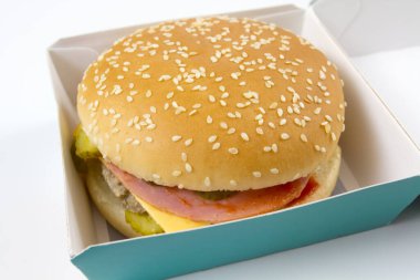 Beyaz arka planda izole edilmiş kağıt kutuda nefis bir çizburger.