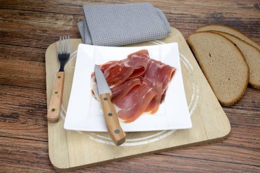 Tabakta kurutulmuş jambon ve bıçak dilimleri