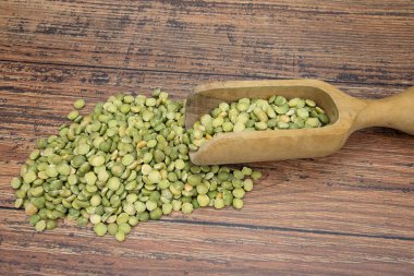 Tahta kepçe içinde yeşil bezelyeler 
