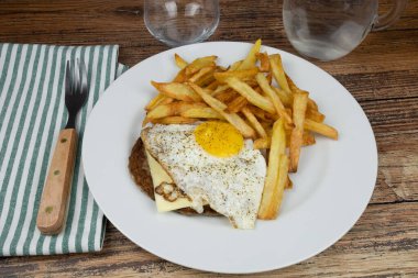 At sırtında biftek ve tabakta patates kızartması.