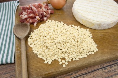 Kesme tahtasındaki Savoyard reblochon croziflettes ve domuz lardons