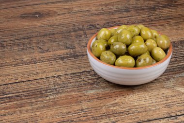 Kekik içinde marine edilmiş yeşil zeytin tabağı