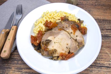 Bir tabak kızarmış domuz ve tagliatelle.