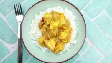 Köri soslu tavuk parçaları ve tabakta pilav..