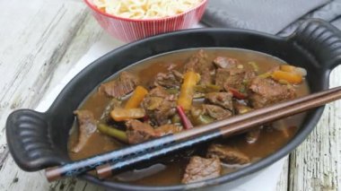 Kırmızı güveçte biber soslu et güveci.