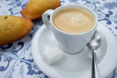 Bir fincan kahve ve makarnalar masada.