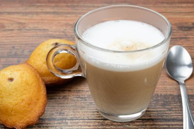 Bir fincan kahve ve makarnalar masada.