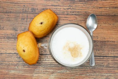 Bir fincan kahve ve makarnalar masada.