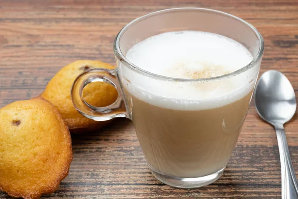 Bir fincan kahve ve makarnalar masada.