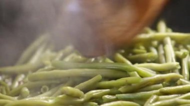 Tavada ahşap spatula ile yeşil fasulye.