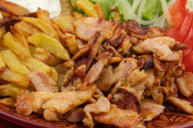 Sebzeli ve patates kızartmalı bir tabak kebap.