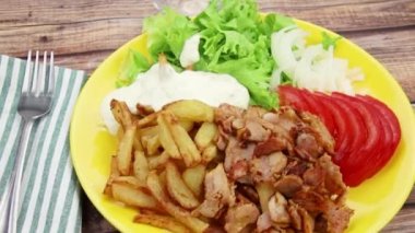 Sebzeli ve patates kızartmalı bir tabak kebap.