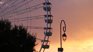 Gün batımının önünde dönme dolap.