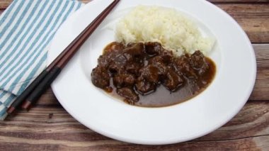 Soğan soslu biftek ve tabakta pilav.