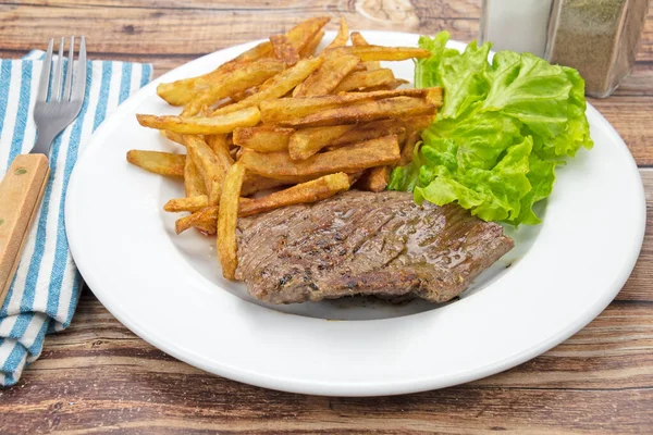 grilled flank steak and fries on a plate