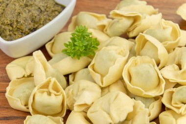Kesme tahtasındaki çiğ tortellini yığını