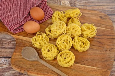 Kesme tahtasındaki çiğ tagliatelle makarnası