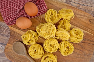 Kesme tahtasındaki çiğ tagliatelle makarnası