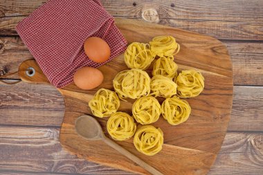 Kesme tahtasındaki çiğ tagliatelle makarnası