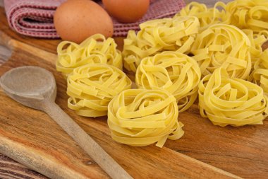 Kesme tahtasındaki çiğ tagliatelle makarnası