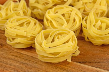Kesme tahtasındaki çiğ tagliatelle makarnası