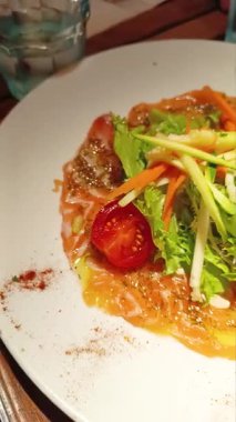 Terbiye edilmiş çiğ sebzeli taze somon carpaccio.