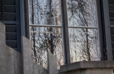 Dışarıyı izlemek ve içeri ışık almak için bir binanın penceresi.