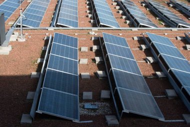 Modern binalarda yenilenebilir enerji kullanan bir evin çatısındaki güneş panelleri.