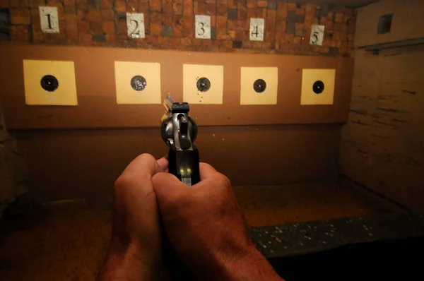 sport shooter at a shooting range firing at the target