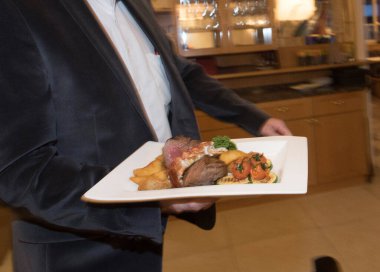 Restoranda garsonlara yemek servisi yapan bir garson.