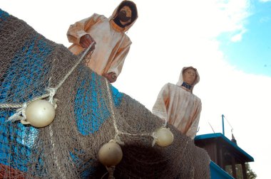 Baltık denizinde balık ağıyla balık yakalayan iki heykel, sembol.